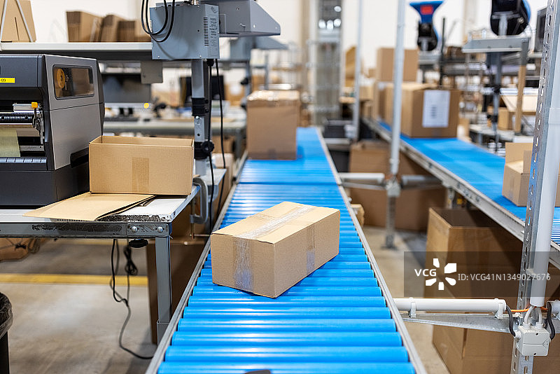 配送仓库包装线上输送带上的纸板箱图片素材
