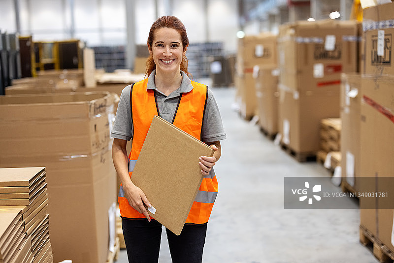 仓库中手持纸箱的女工肖像图片素材