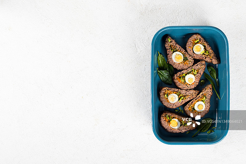 烤肉料理，牛肉卷配鹌鹑蛋、胡萝卜、洋葱、绿色蔬菜和菠菜图片素材