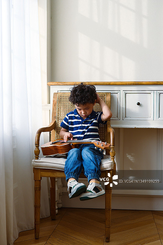 弹尤克里里的小男孩图片素材