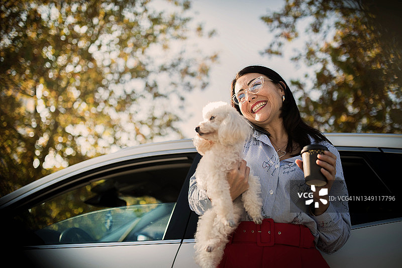 在车内使用手机和笔记本电脑的女商人图片素材