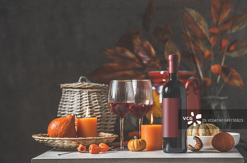 秋季晚餐餐桌布置（红酒、酒杯、南瓜和蜡烛）图片素材
