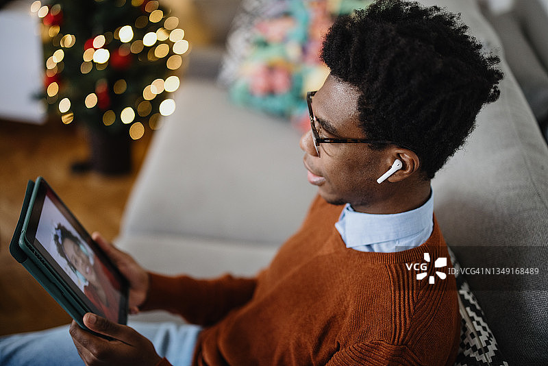 圣诞节与家人视频通话的年轻男人图片素材