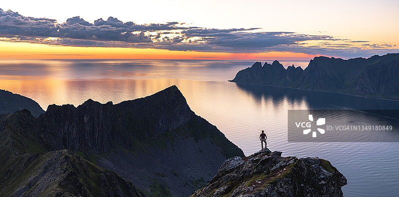 男人在挪威山顶黎明时分欣赏峡湾图片素材