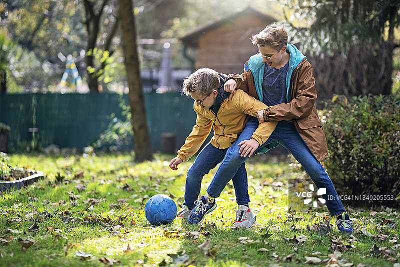 青少年男孩在后院玩足球图片素材