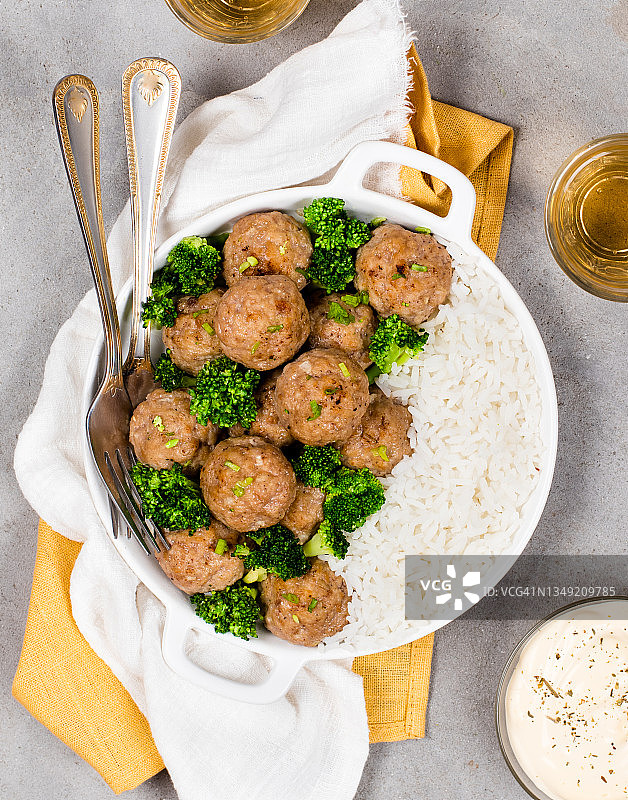 餐厅热餐，肉丸西兰花米饭，陶瓷盘，亚麻餐巾，浅灰色背景，俯视图图片素材