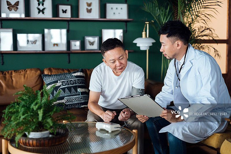 年长的亚洲男性患者与男医生交谈，在家访期间讨论健康问题并提供专业建议，老年人保健概念图片素材