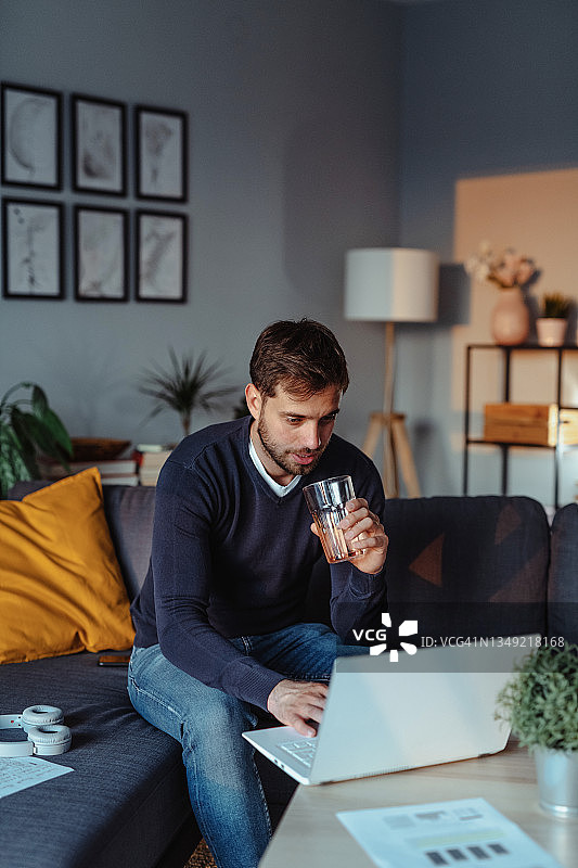 在家用笔记本电脑在沙发上工作的男人图片素材