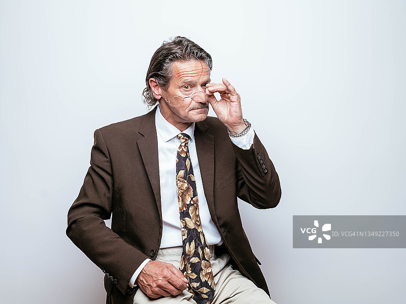 摆弄眼镜的中年商人图片素材