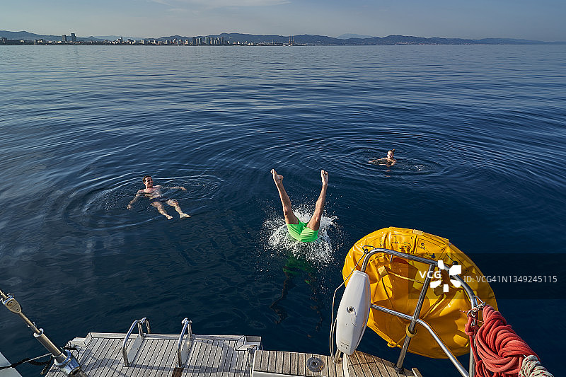 从船上跳入海中的男子下半身图片素材