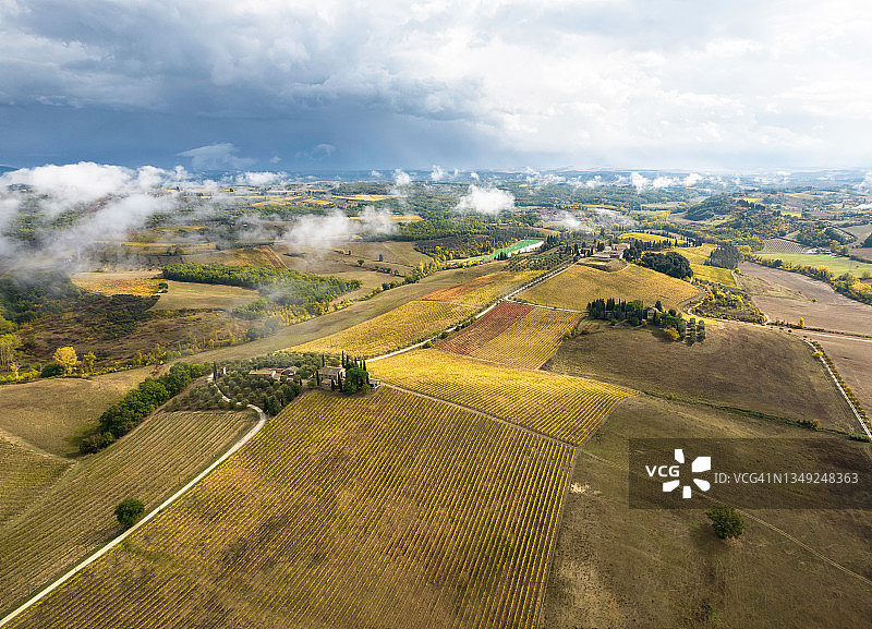 从空中看到的锡耶纳附近基安蒂地区雷雨过后美丽的秋色葡萄园图片素材