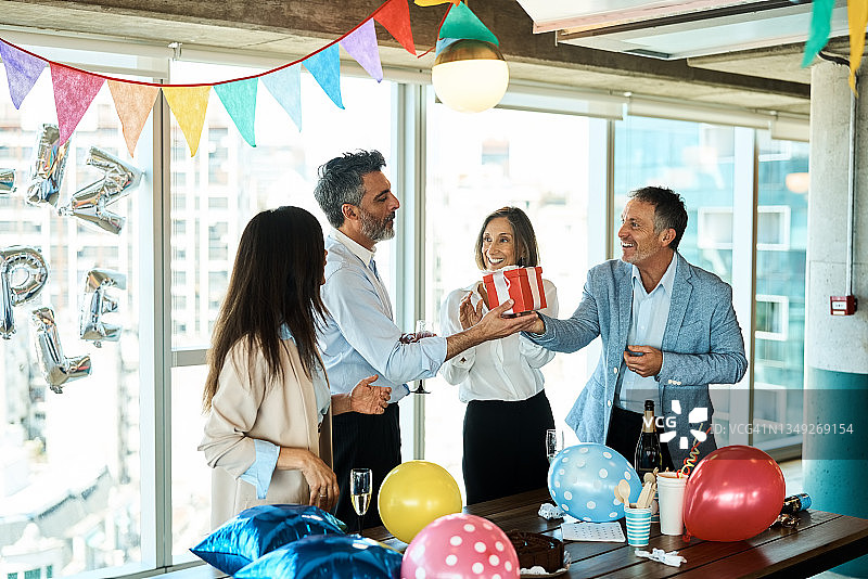 商人收到同事在办公室送的生日礼物图片素材