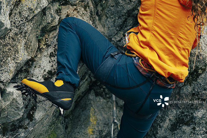 攀岩者脚穿冰爪攀爬岩壁特写图片素材