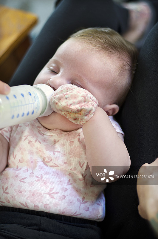 婴儿使用奶瓶喝奶图片素材