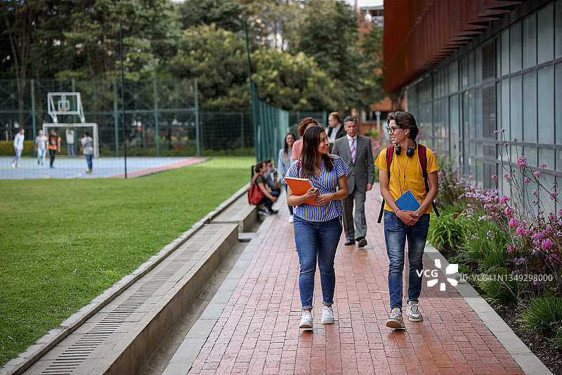 快乐的大学生在大学校园里交谈。图片素材