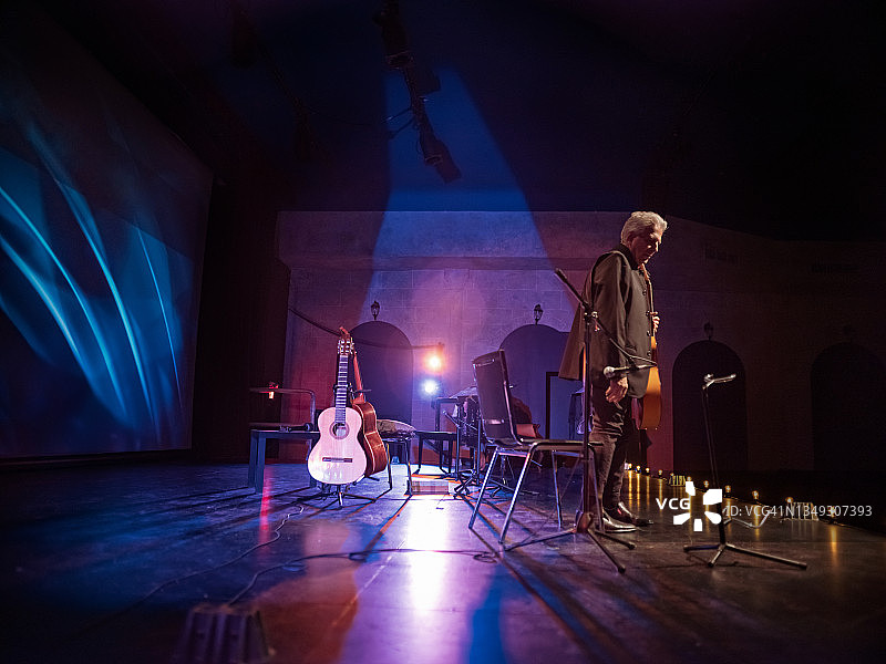 年长的男吉他手在舞台上演奏古典吉他图片素材