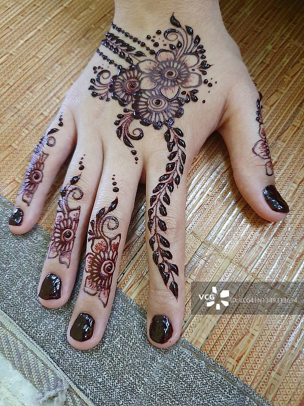 竹席上装饰有指甲花的右手图片素材