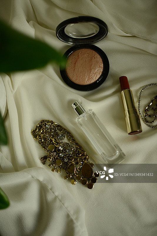 白色背景上的香水瓶和红色口红图片素材