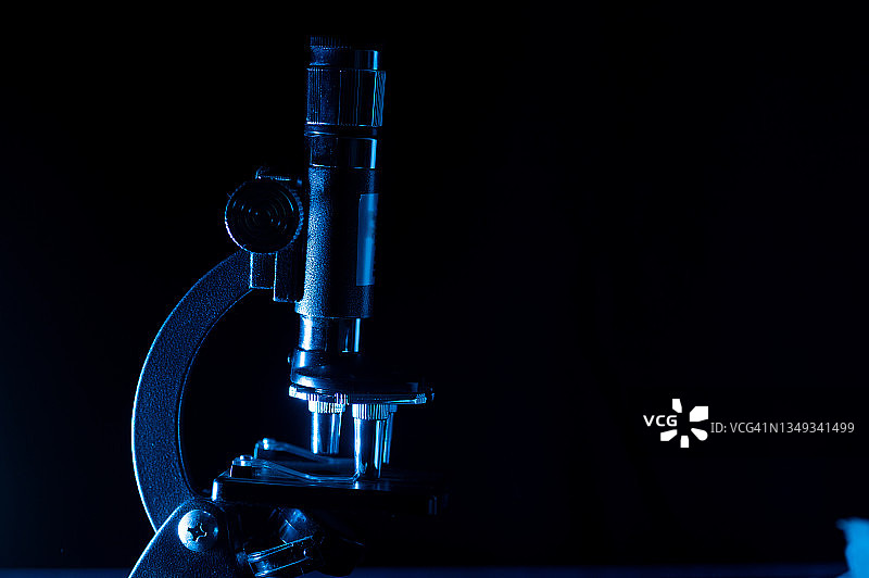 黑色背景下的显微镜研究调查概念图片素材