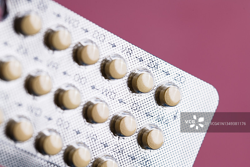 粉色背景上的口服避孕药图片素材