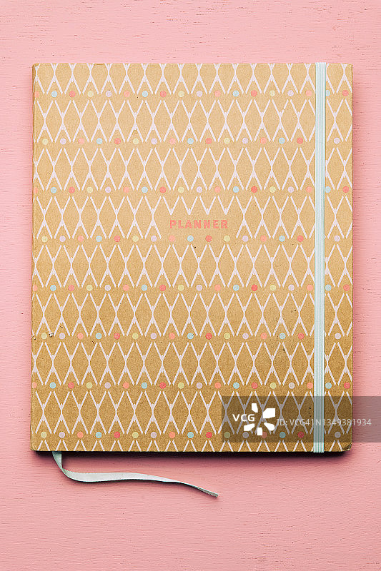 粉色背景上的计划本图片素材