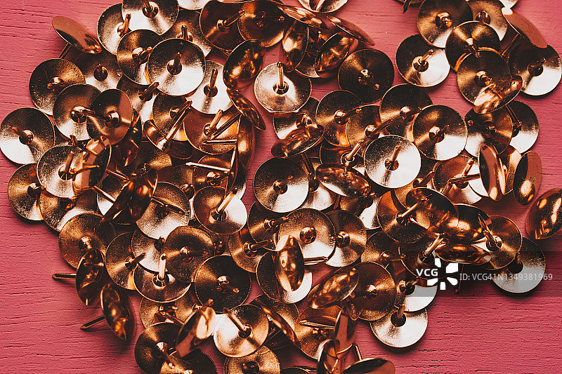 粉色背景上的金色图钉图片素材