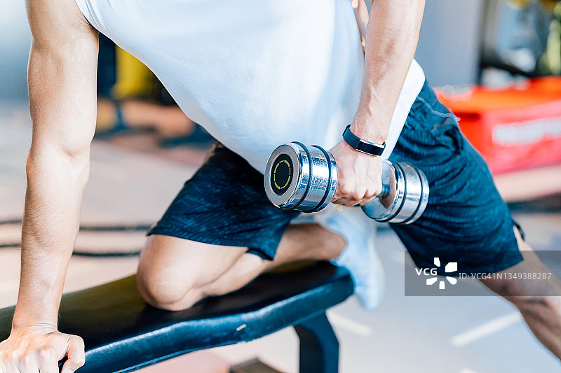 在健身房用哑铃锻炼的健壮男人，健康和健身概念图片素材