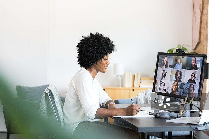 女人在虚拟会议中与不同同事做笔记图片素材