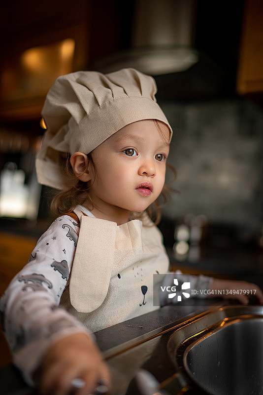 儿童在厨房准备烹饪食物的肖像图片素材