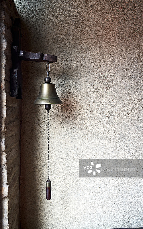 挂在砖墙上的黄铜钟特写图片素材