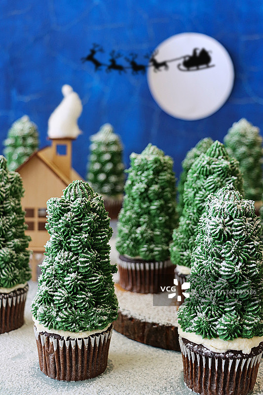 圣诞树巧克力纸杯蛋糕，雪夜森林场景图片素材