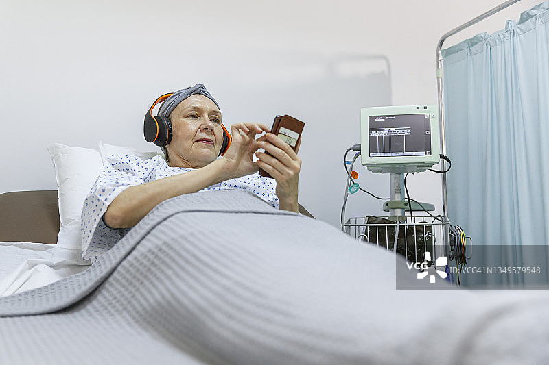 住院期间使用智能手机的患癌年长女性图片素材