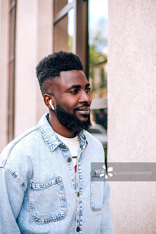 年轻的黑人商人户外用手机听音乐图片素材