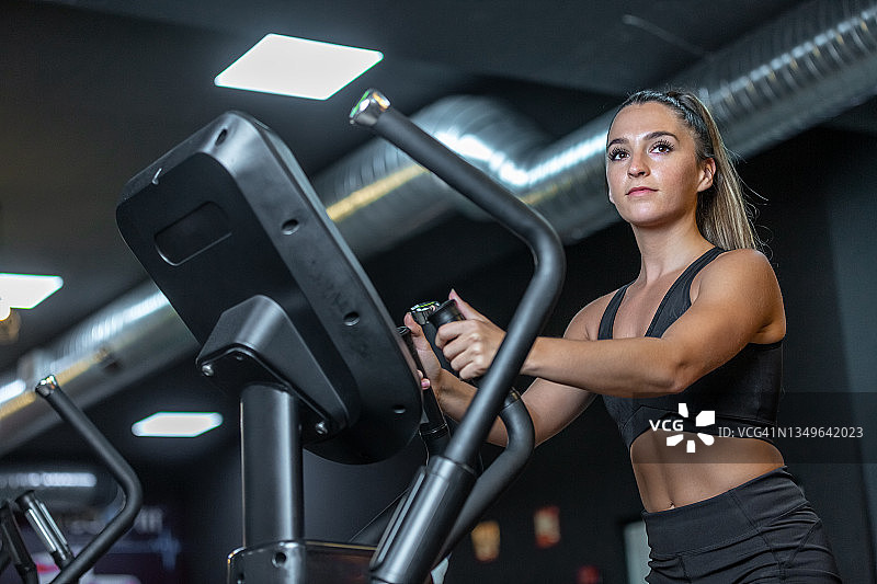 在椭圆自行车上锻炼的女人肖像图片素材