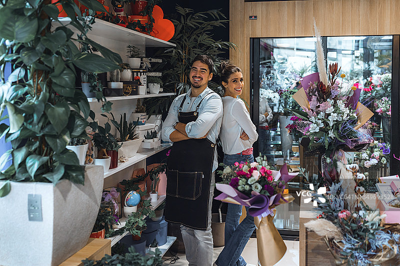 花店里的花艺师情侣对着镜头摆姿势图片素材