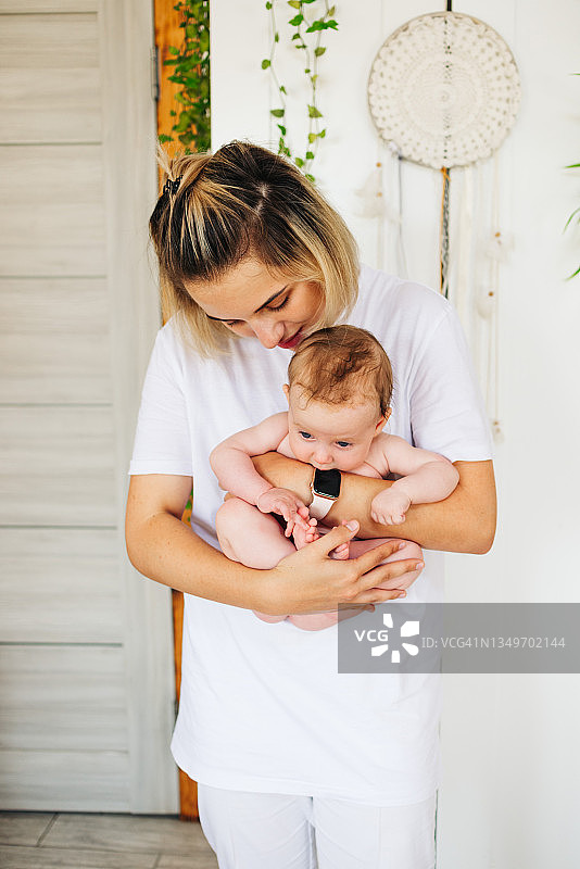 年轻女孩为婴儿按摩，儿科健康概念图片素材