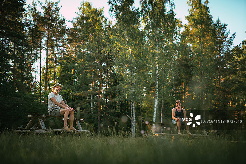 在野外露营：朋友们在森林空地上放松图片素材