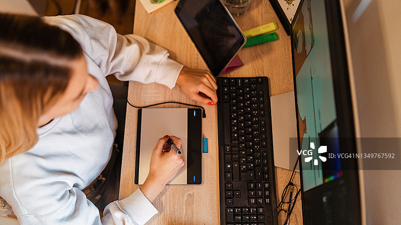 女性平面设计师在绘图板上绘图的俯视图图片素材