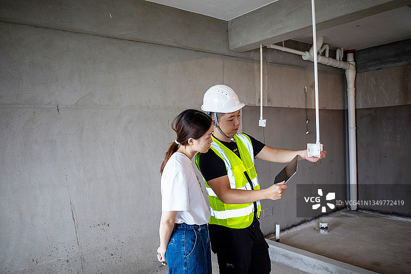 年轻工程师与女业主讨论装修方案图片素材