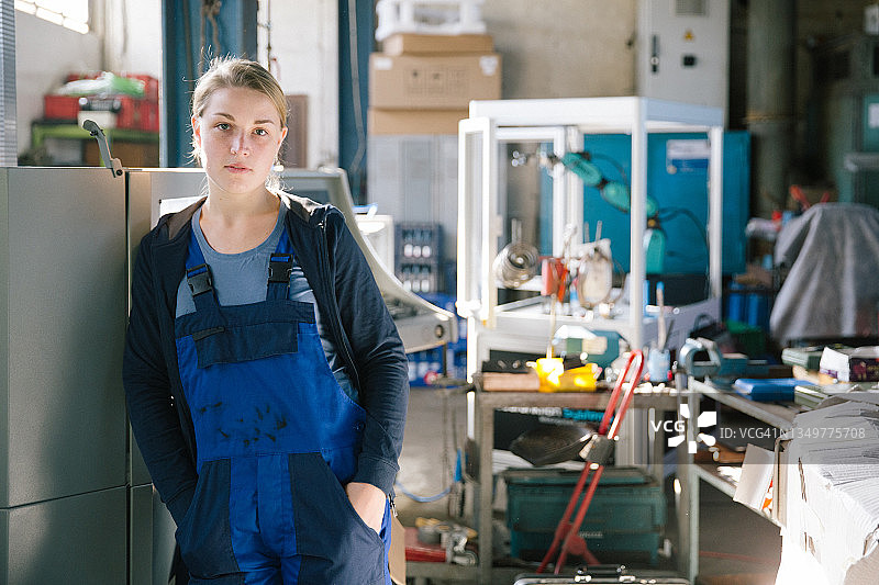 在制造工厂里的年轻女子肖像图片素材