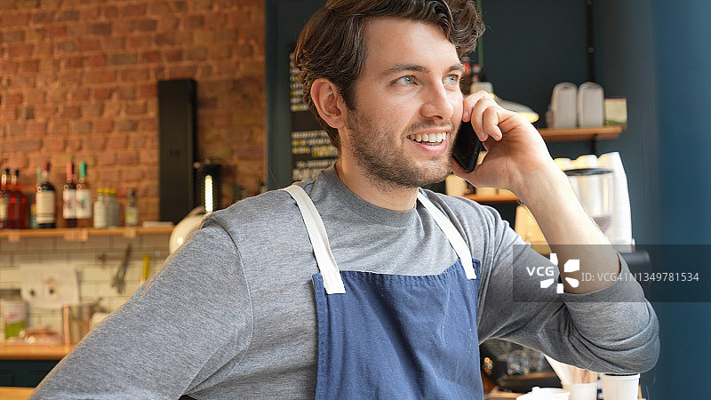 咖啡馆店主用手机交谈图片素材