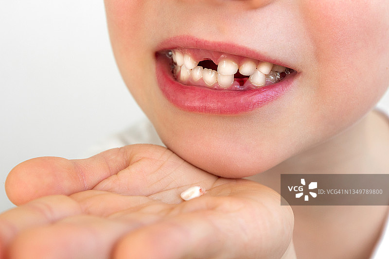 特写：小孩展示掉落的第一颗牙齿图片素材