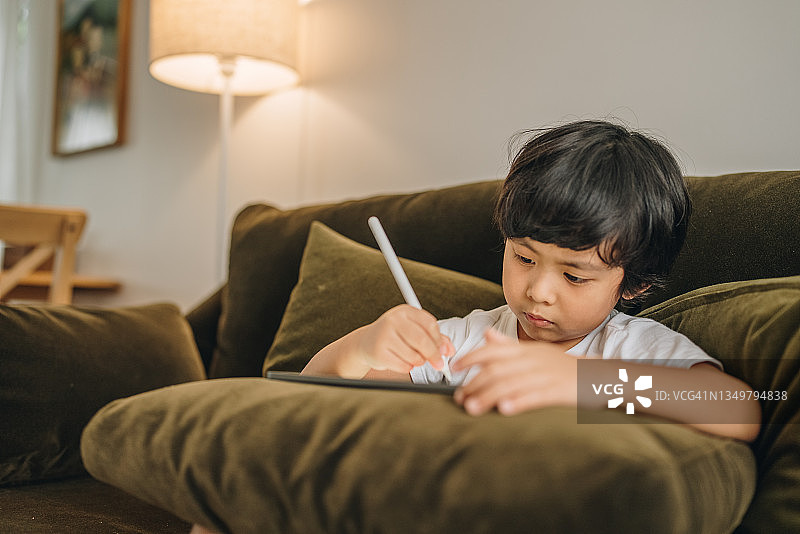 在家用平板电脑做作业的男婴图片素材