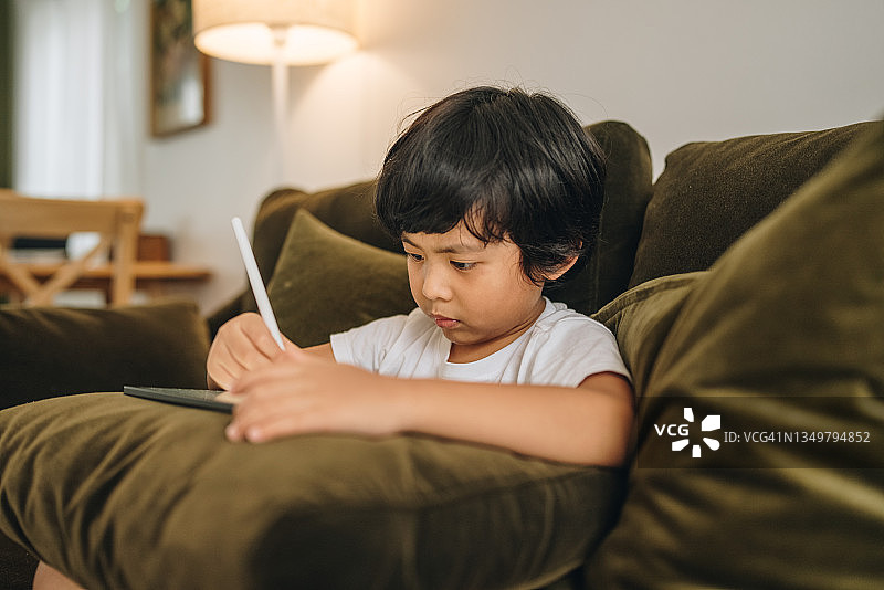 在家用平板电脑做作业的男婴图片素材