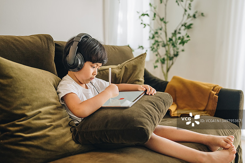 亚洲男孩用数位板进行绘画创作图片素材