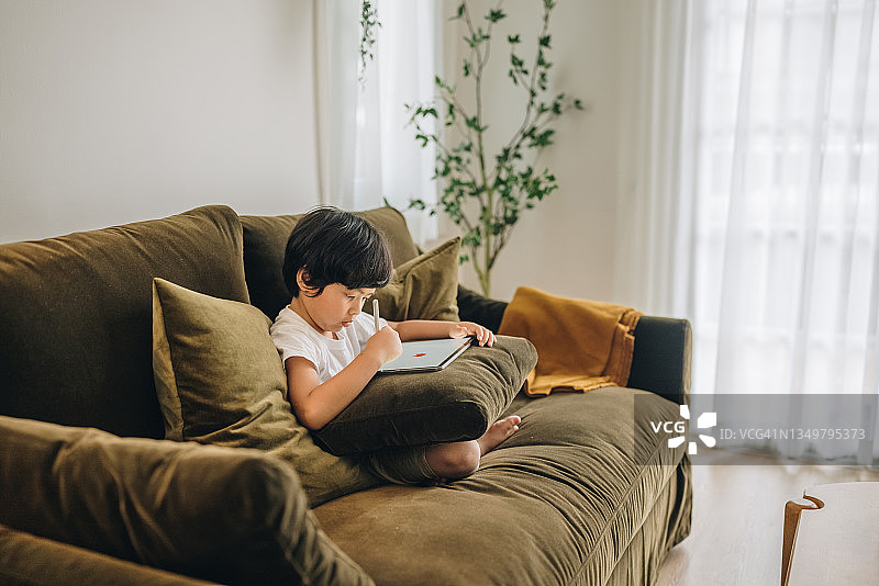 在家用平板电脑做作业的男婴图片素材