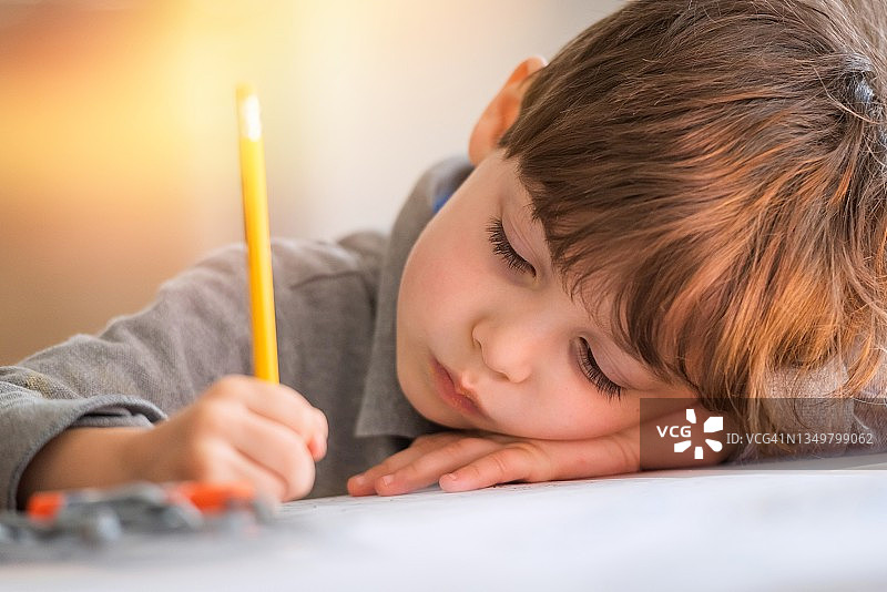 小男孩在幼儿园教室里完成作业图片素材