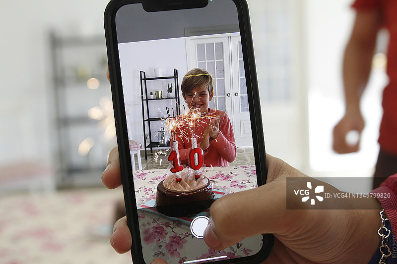 在生日时为儿子拍照的女人图片素材