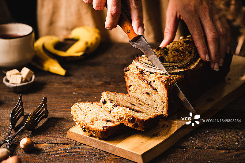 女人切香蕉面包的特写图片素材