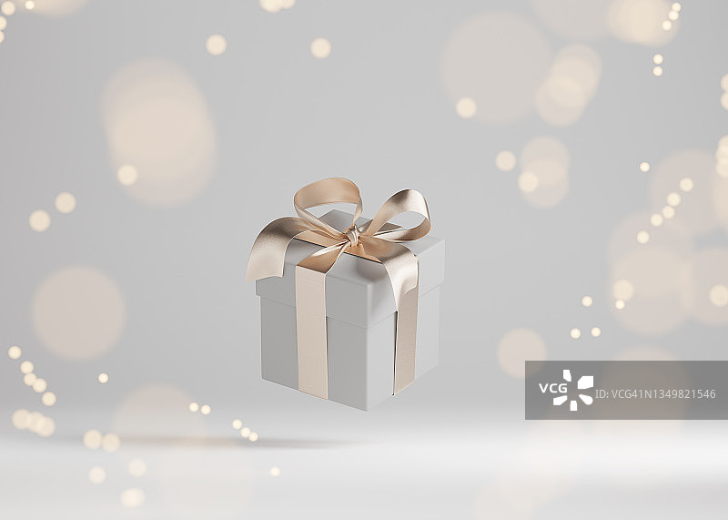 灰色背景上带有金色丝带蝴蝶结的白色礼品盒图片素材